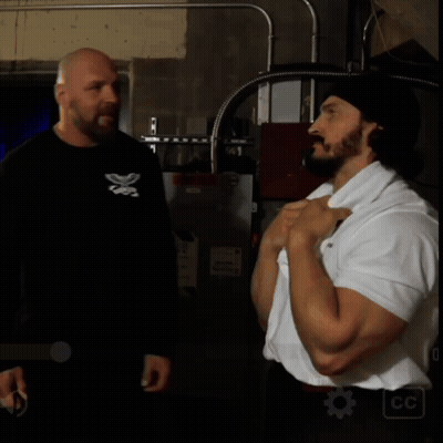 Man In Black Shirt With Butterfly Talking To Man In White Shirt GIF