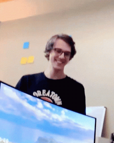 Man In Black Shirt With Creations Smiles GIF