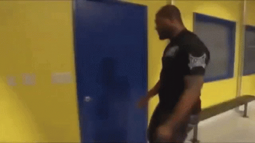 Man in Black Shirt With Everlast Walking Through Blue Door