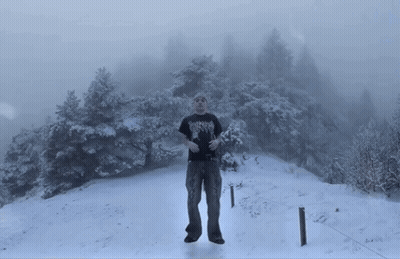 Man In Black Shirt With Heavy Metal In Snow GIF