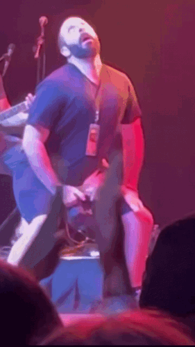 Man In Black Shirt With Lanyard On Stage GIF