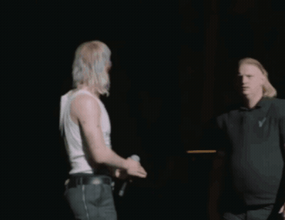 Man In Black Shirt With Letter V Next To Another Man GIF