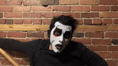 Man In Black Shirt With S Next To Face Painted Man GIF