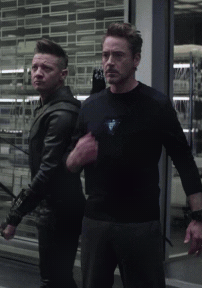 Man In Black Shirt With Triangle Next To Man In Black Jacket GIF