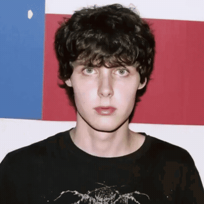 Man In Black Skull Shirt Pointing At Camera GIF