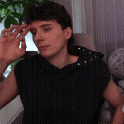 Man In Black Sleeveless Hoodie Sitting In Chair GIF
