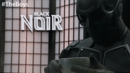 Man in Black Suit Holding Cup With Black Noir