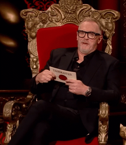 Man In Black Suit Holding Taskmaster Paper GIF