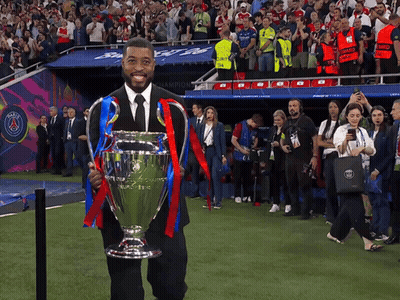 Man In Black Suit Holding Trophy In Front Of Crowd GIF