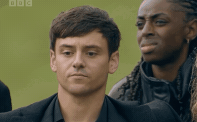 Man In Black Suit In Front Of BBC Green Background GIF