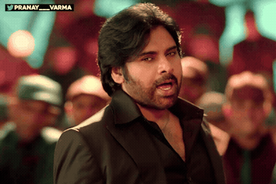 Man In Black Suit In Front Of Crowd With Pranay Varma Above GIF