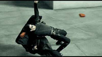 Man In Black Suit Laying On Ground With Red Object GIF