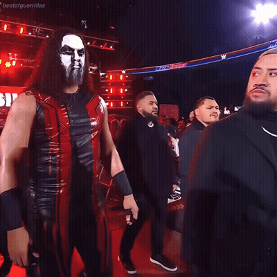 Man In Black Suit Next To Man In Red Jacket GIF