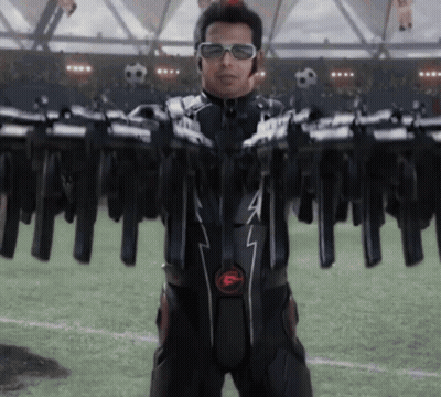 Man In Black Suit With F Holding Guns GIF