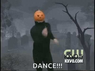 Man In Black Suit With Pumpkin Head Dancing In Cemetery GIF