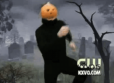 Man In Black Suit With Pumpkin Head Dancing In Cemetery GIF