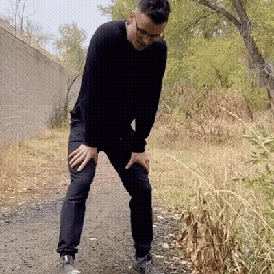 Man In Black Sweater Holding Knee In Pain GIF
