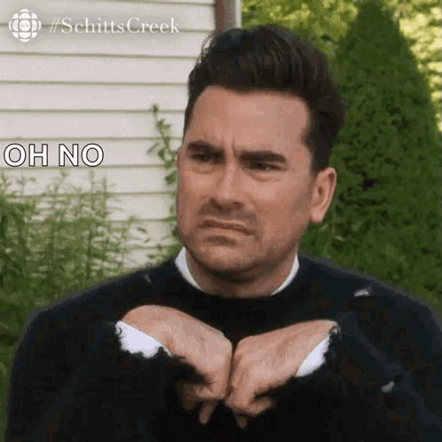 Man In Black Sweater Making Funny Face Holding Hands Together GIF