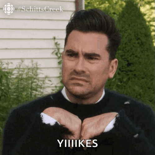 Man In Black Sweater Making Funny Face Says Yiiikes GIF
