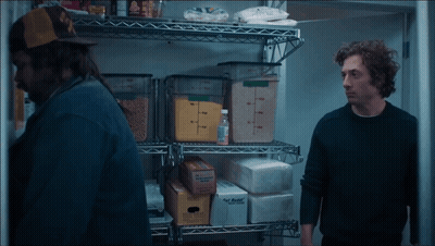 Man In Black Sweater Next To Man In Yellow Hat GIF