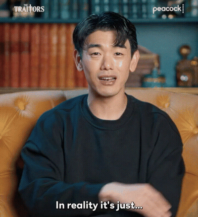 Man In Black Sweater On Yellow Couch Saying In Reality It's Just GIF