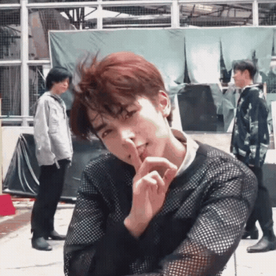 Man In Black Sweater Shushing Another Man GIF