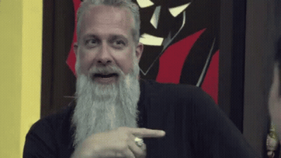 Man In Black Sweater Sitting In Front Of Purple Wall GIF