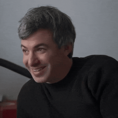 Man In Black Sweater Smiling At Camera GIF