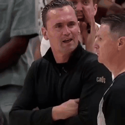 Man In Black Sweater With Cavs Sleeve Talking To Another Man GIF