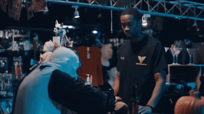 Man In Black T-Shirt With Eagle Talks To Another Man GIF