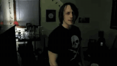 Man In Black T-Shirt With Skull In Dark Room GIF
