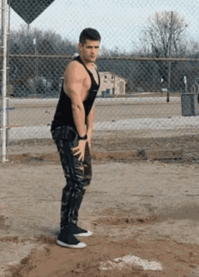 Man In Black Tank Top And Camo Pants At Chain Link Fence GIF