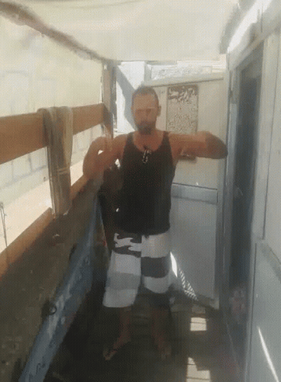 Man In Black Tank Top And White Shorts In Front Of Door GIF