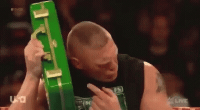 Man In Black Tank Top Holding Green Briefcase Over Head GIF