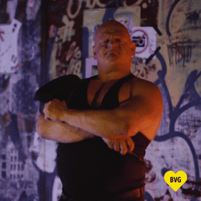 Man In Black Tank Top In Front Of Graffiti Wall With Yellow Heart GIF