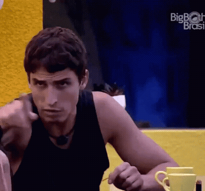 Man In Black Tank Top Sitting At Table With Two Coffee Cups And Big Brother Logo GIF