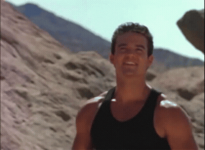 Man In Black Tank Top Smiling In Desert GIF