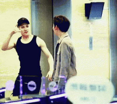 Man In Black Tank Top Talking To Man In Grey Jacket GIF