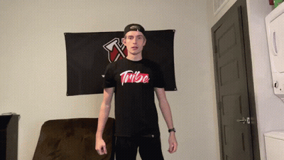 Man In Black Tribe Shirt In Front Of Black Flag GIF