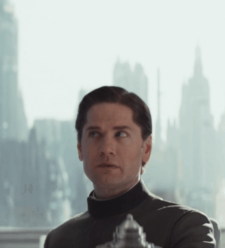 Man In Black Turtleneck Looking Out Window With City GIF