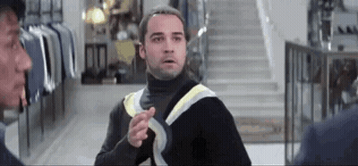 Man In Black Turtleneck Pointing At Another Man GIF