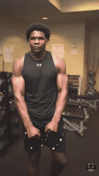 Man In Black Under Armour Tank Stretches GIF