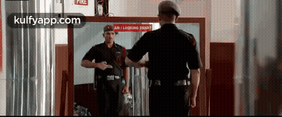Man In Black Uniform Looking In Mirror GIF