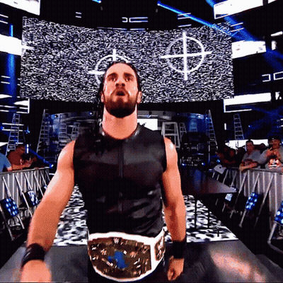 Man In Black Vest With Gold Belt Before Screen With Letter D GIF