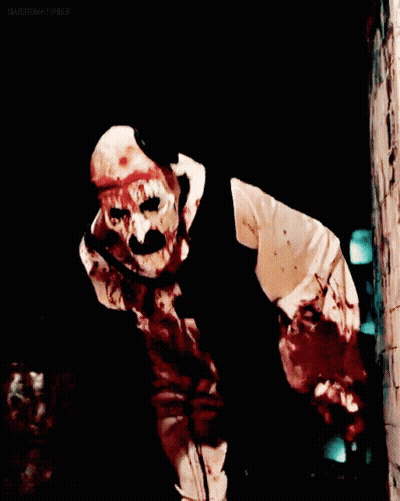 Man In Bloody Clown Costume In Dark Room GIF