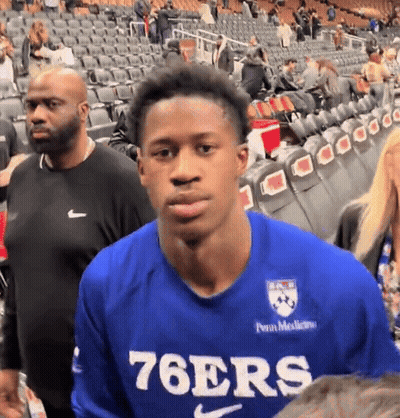 Man In Blue 76Ers Shirt In Crowded Stadium GIF