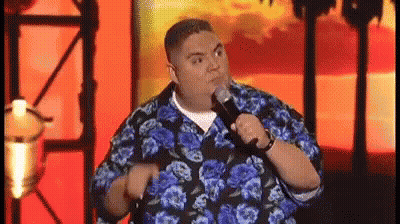 Man In Blue And Black Floral Shirt Holding Microphone Making Funny Face GIF