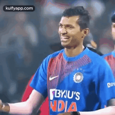 Man In Blue And Red Striped Shirt Smiling On Field GIF
