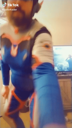 Man In Blue And White Costume Dancing In Front Of TV GIF