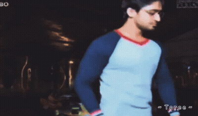 Man In Blue And White Shirt In Dark Room With Toree GIF